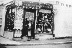 002810 Jim Southwood Saddlers and harness makers shop, New Road, decorated for the Coronation showing the youngest daughter in the doorway 1937
